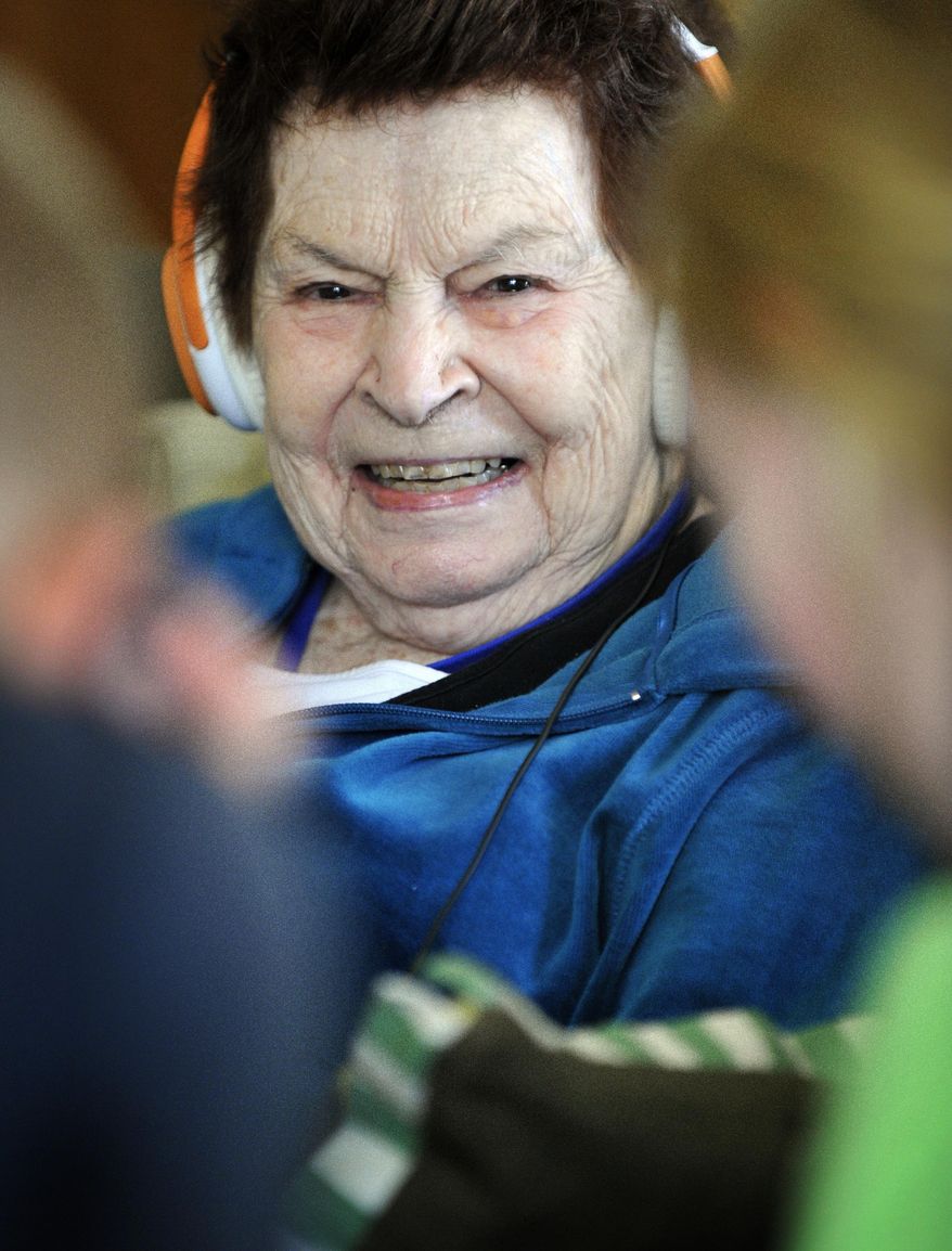 In this Tuesday, Nov. 15, 2016 photo, resident Marcella Niedfeldt laughs with visitors from Faith Lutheran in Lincoln, Neb. (Eric Gregory /The Journal-Star via AP)