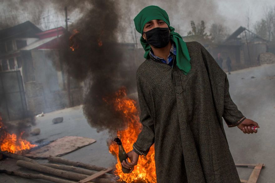 A Kashmiri villager prepares to throw a Molotov cocktail at Indian police during a protest on Sunday. (Associated Press)