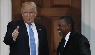 President-elect Donald Trump calls out to media as he poses for photos with BET founder Robert Johnson at the Trump National Golf Club Bedminster clubhouse, Sunday, Nov. 20, 2016, in Bedminster, N.J.. (AP Photo/Carolyn Kaster)