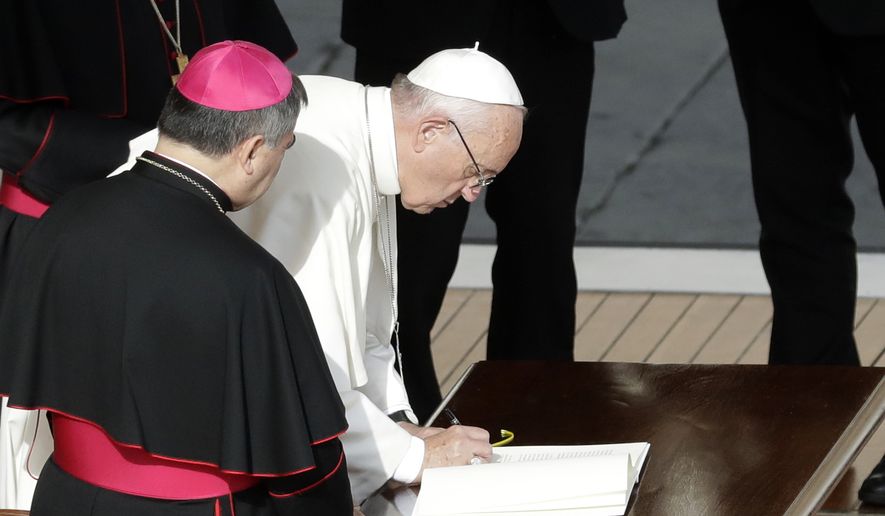 Pope Francis signs a letter at the end of a Mass on the occasion of the closing of the Holy Door of St. Peter&#x27;s Basilica at the Vatican, Sunday, Nov. 20, 2016. The Vatican said the letter, addressed to all the church,  expressed the pope&#x27;s intention that the church can continue to live out the mercy with the same intensity felt during the entire special Jubilee Holy Year.  (AP Photo/Gregorio Borgia)