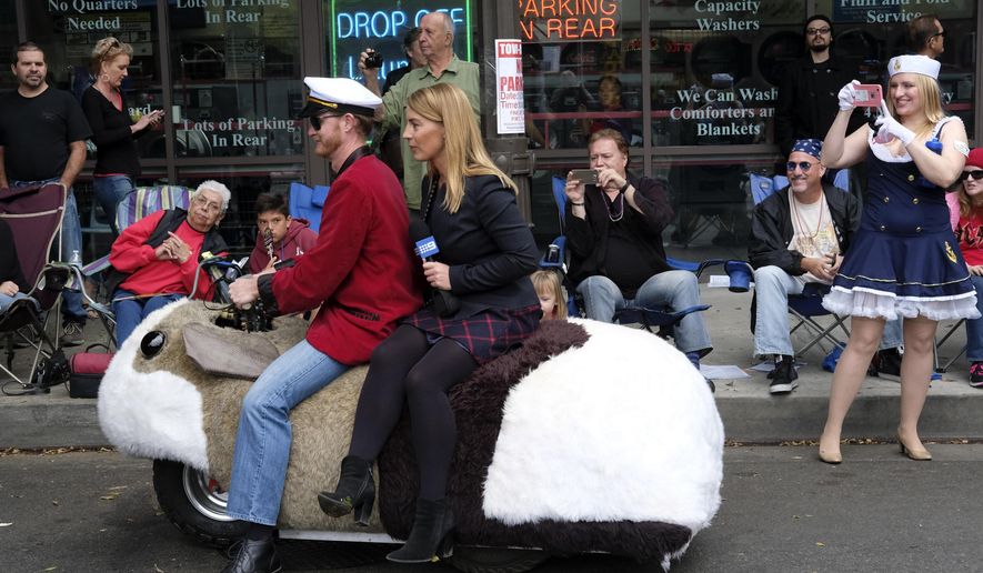 A news reporter sits on the back of a vehicle outfitted as a hamster as she reports on the 39th Occasional Pasadena Doo Dah Parade on Sunday, Nov. 20, 2016 in Pasadena, Calif. Known for it's inventive, zany parade of art cars and floats, the parade began as a grassroots event in 1978 and gained national attention for its eccentric and, often, irreverent satire. (AP Photo/Richard Vogel)