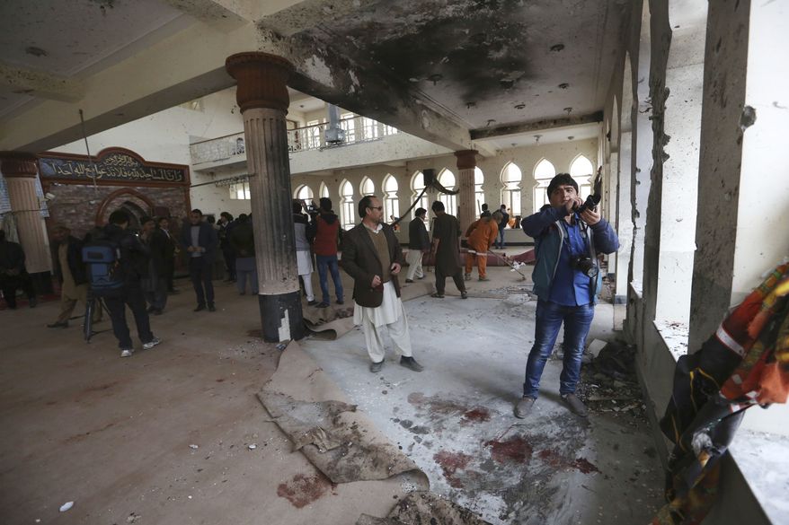 Afghans are seen inside the Baqir-ul Ulom mosque after a suicide attack, in Kabul, Afghanistan, Monday, Nov. 21, 2016. An Afghan official says that dozens of civilians have been killed after a suicide bomber attacked a Shiite mosque in the capital. (AP Photo/Rahmat Gul)