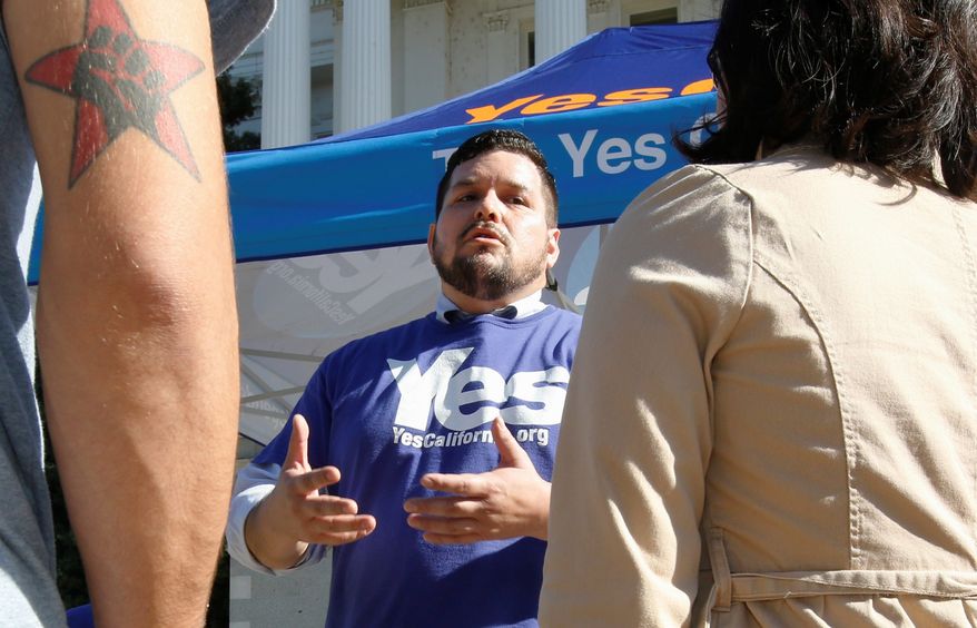 FILE - In this Nov. 9, 2016 file photo, Marcus Ruiz Evans, center, of The Yes California Independence Campaign, talks to passersby about California succeeding from the United States and becoming its own nation in Sacramento, Calif. A group calling for California to secede from the United States submitted a proposed petition Monday, Nov. 21, 2016, seeking a ballot measure that would strip the state constitution of language that says California is an inseparable part of the nation. The Yes California Independence Campaign hopes to put a question on the November 2018 ballot authorizing a vote on independence in spring 2019. (AP Photo/Rich Pedroncelli, File)