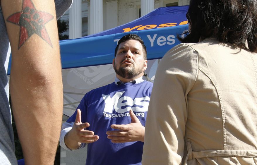 Marcus Ruiz Evans (center) of The Yes California Independence Campaign, talks to passersby about California succeeding from the United States and becoming its own nation in Sacramento on Nov. 9, 2016. A group calling for California to secede from the United States submitted a proposed petition Monday, Nov. 21, 2016, seeking a ballot measure that would strip the state constitution of language that says California is an inseparable part of the nation. The Yes California Independence Campaign hopes to put a question on the November 2018 ballot authorizing a vote on independence in spring 2019. (Associated Press) **FILE**