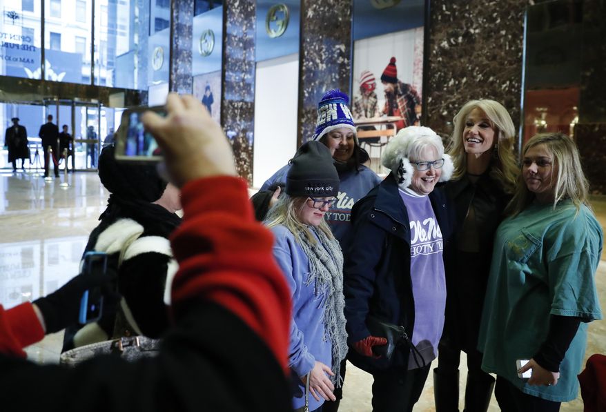 President-elect Donald Trump's campaign manager Kellyanne Conway poses with tourists for photographs in the lobby of Trump Tower in New York, Monday, Nov. 21, 2016. Welcome to Trump Tower. Upstairs, the President-elect is planning his administration. Downstairs it’s a full-on political carnival. Since Donald Trump’s stunning presidential victory, the celebrity businessman has largely been ensconced in his penthouse home at his 664-foot glass tower on Manhattan’s Fifth Avenue. But as he works, the political circus that has accompanied his spectacular rise unfolds in the building’s marble-floored, gold-plated public lobby before crowds of journalists, supporters and wide-eyed gawkers. (AP Photo/Carolyn Kaster)