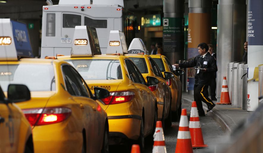 In this Wednesday, May 4, 2016, photo, a taxi dispatcher hands a piece of paper to a driver as other taxis line up awaiting passengers outside the arrivals area of a terminal at LaGuardia Airport, in New York. Airports across the country add surcharges of up to $5 a ride, typically passed directly on to travelers, for trips originating at their curbs. There are similar charges for limousine, Uber and Lyft drivers as well as shuttle buses for hotels, car rental companies and off-airport parking lots. (AP Photo/Kathy Willens)
