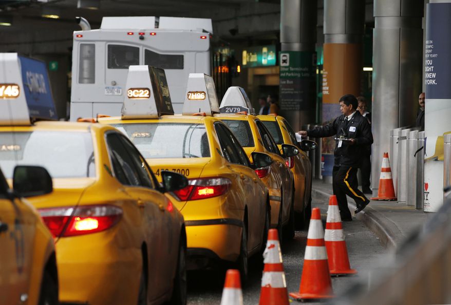 In this Wednesday, May 4, 2016, photo, a taxi dispatcher hands a piece of paper to a driver as other taxis line up awaiting passengers outside the arrivals area of a terminal at LaGuardia Airport, in New York. Airports across the country add surcharges of up to $5 a ride, typically passed directly on to travelers, for trips originating at their curbs. There are similar charges for limousine, Uber and Lyft drivers as well as shuttle buses for hotels, car rental companies and off-airport parking lots. (AP Photo/Kathy Willens)