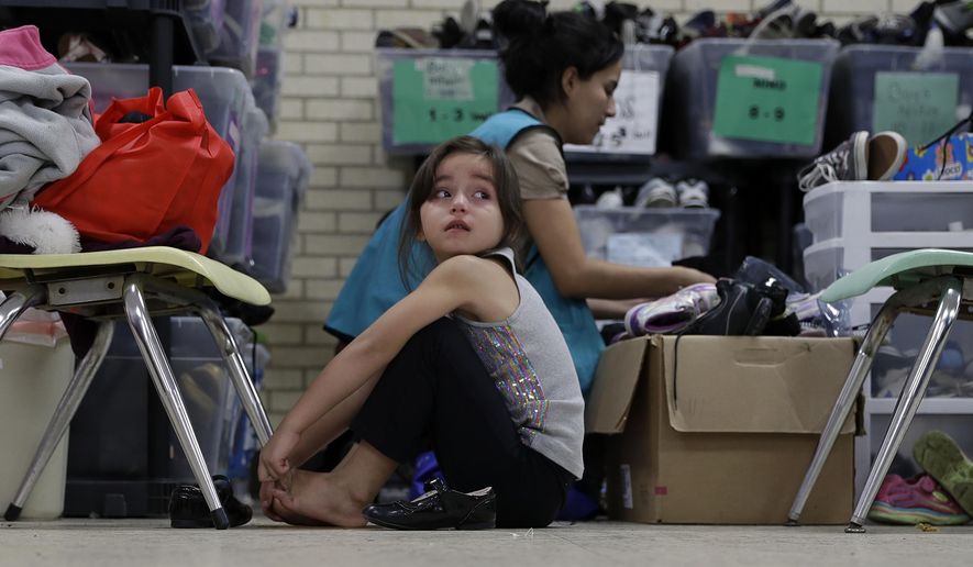 In this Sunday, Nov. 13, 2016, photo, a young migrants girl from Central American newly released after processing by the U.S. Customs and Border Patrol is fitted shoes at the Sacred Heart Community Center in the Rio Grande Valley border city of McAllen, Texas, Sunday, Nov. 13, 2016. (AP Photo/Eric Gay)