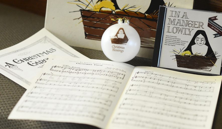 This Nov. 10, 2016 photo shows a CD, written music and an ornament commemorating the 100th anniversary of "In a Manger Lowly," a Christmas song written by a nun of The Sisters of St. Joseph convent in Baden, Pa. (Lucy Schaly/Beaver County Times via AP)