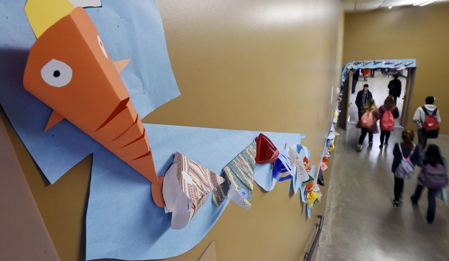 ADVANCE FOR WEEKEND EDITIONS - In this Nov. 17, 2016, photo, a stream of koi winds through the halls at the Discovery Canyon Campus in Colorado Springs, Colo., each fish handmade by students, teachers, faculty and parents. Last year, five kids committed suicide from the Discovery Canyon Campus school. The name of the art project is "Keep Swimming" and signifies that each student has someone behind them to help them through rough times. (Jerilee Bennett/The Gazette via AP)