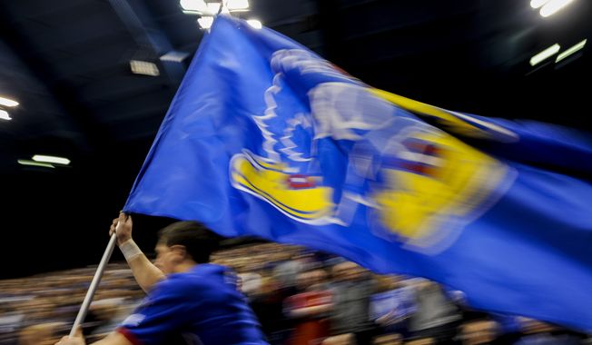 A University of Kansas cheerleader leads the team out on the court before their game NCAA college basketball against the Kansas State Wildcats game Wednesday, Feb. 3, 2016, in Lawrence, Kan. Kansas  beat K-State, 77-59. (AP Photo/Reed Hoffmann) ** FILE **