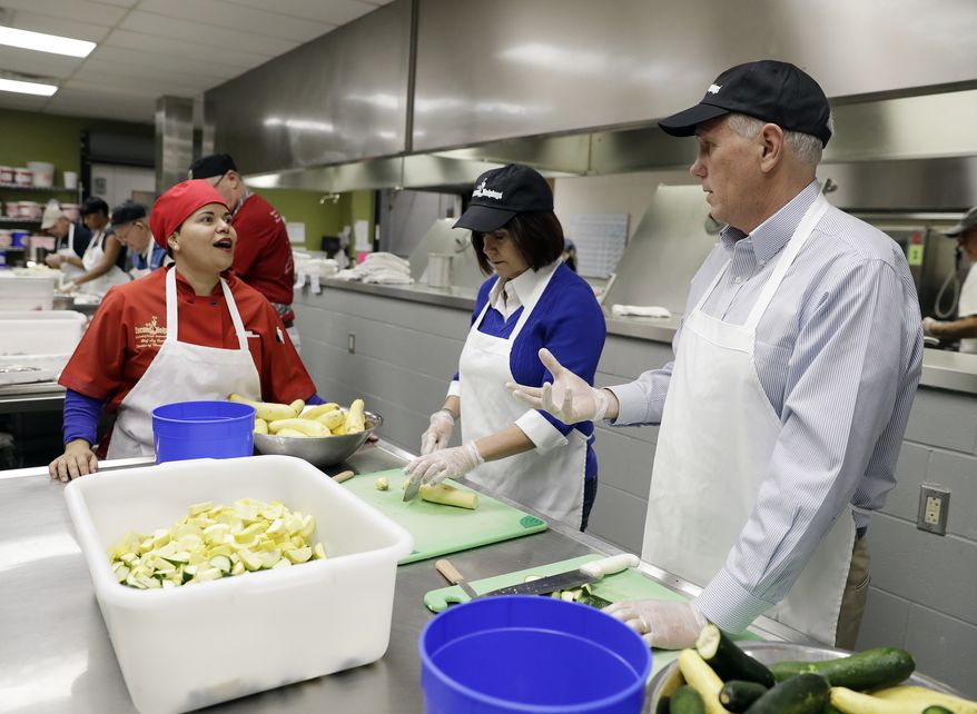 Vice President-elect Mike Pence and his wife, Karen, talk with Second Helpings' Chef Liz Gimenez as they slice vegetables for Thanksgiving meals, Wednesday, Nov. 23, 2016, in Indianapolis. (AP Photo/Darron Cummings)
