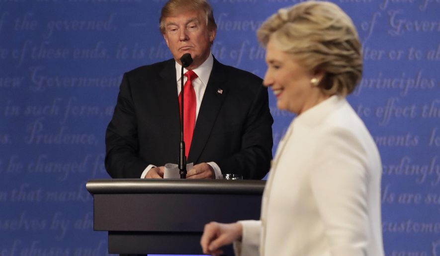 FILE - In this Oct. 19, 2016 file photo, Republican presidential nominee Donald Trump waits behind his podium as Democratic presidential nominee Hillary Clinton makes her way off the stage following the third presidential debate at UNLV in Las Vegas. (AP Photo/David Goldman)