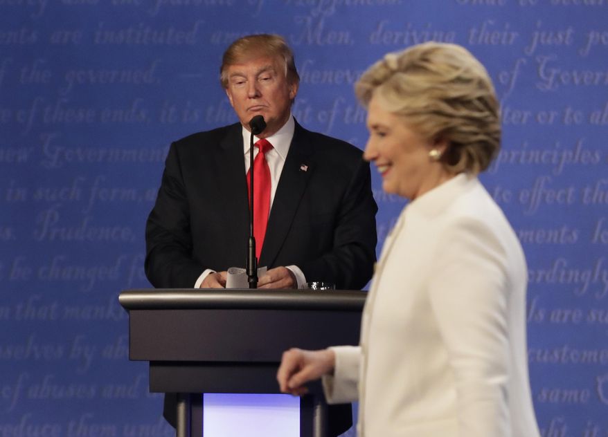 FILE - In this Oct. 19, 2016 file photo, Republican presidential nominee Donald Trump waits behind his podium as Democratic presidential nominee Hillary Clinton makes her way off the stage following the third presidential debate at UNLV in Las Vegas. (AP Photo/David Goldman)