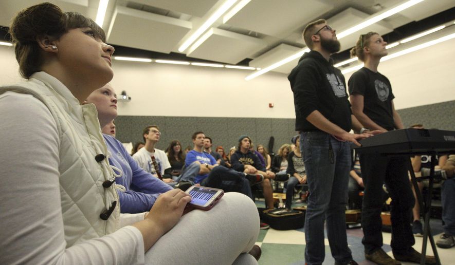 In this Oct. 31, 2016 photo, Millikin student Aimee Frost, left, plays on a keyboard application along with Decatur Public School music teachers Nathan Seals, center, and Robert Lark, right, during the "Teaching the Keyboard" segment of the Little Kids Rock workshop. The workshop was held for local music school teachers and music education majors at Kirkland Fine Arts Center in Decatur, Ill. (Jim Bowling/Herald & Review via AP)