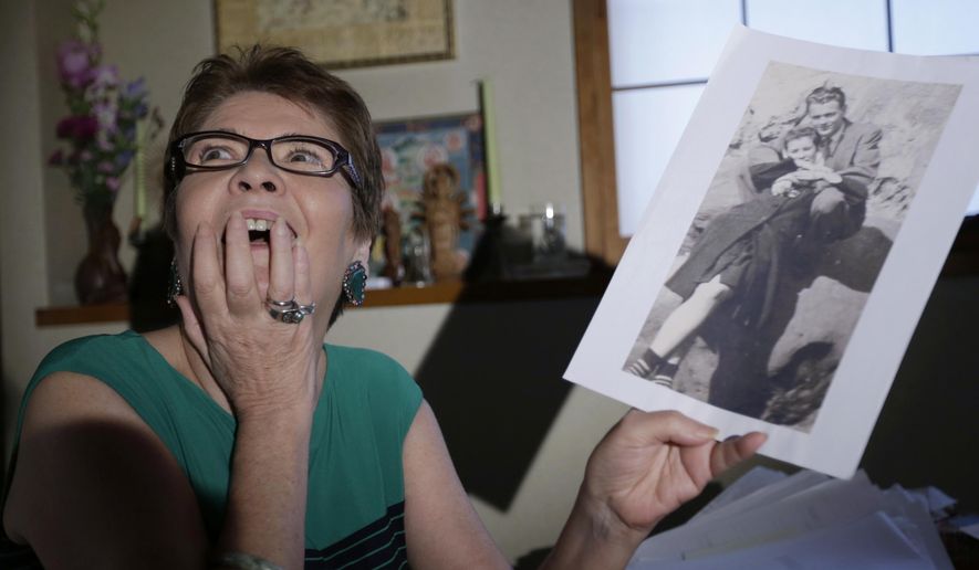In this Sept. 9, 2016 photo, Marianne Wilson Kuroda holds a photo of her father James Vaughn and her mother Vivienne Wilson from late 1940's as she speaks during an interview at her home in Kashiwa, east of Tokyo. Red-haired girl Marianne in a Japanese slum knew she was different, but she didn’t know why; six decades later, she finally put the last piece of her shattered identity into place. Marianne Wilson was torn from her parents - by U.S. immigration policy and by fate - before she was old enough to remember them. It took her decades to learn the truth, and decades more to reclaim her family. (AP Photo/Eugene Hoshiko)