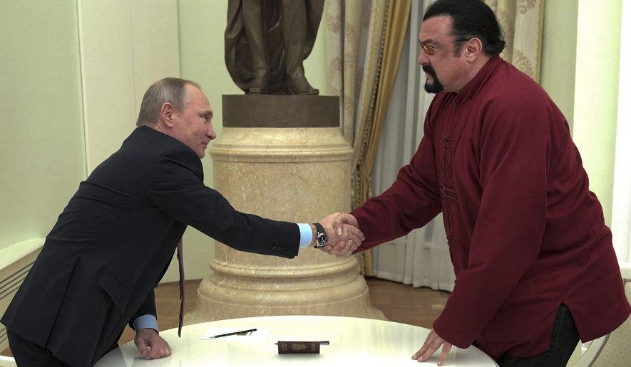 Russian President Vladimir Putin shakes hands with U.S. actor Steven Seagal in the Kremlin in Moscow,Friday, Nov. 25, 2016. Putin has given a Russian passport to Seagal, a regular visitor to Russia in recent years, calling it a sign of a thaw in relations between the two countries. (Alexei Druzhinin/Sputnik, Kremlin Pool Photo via AP)