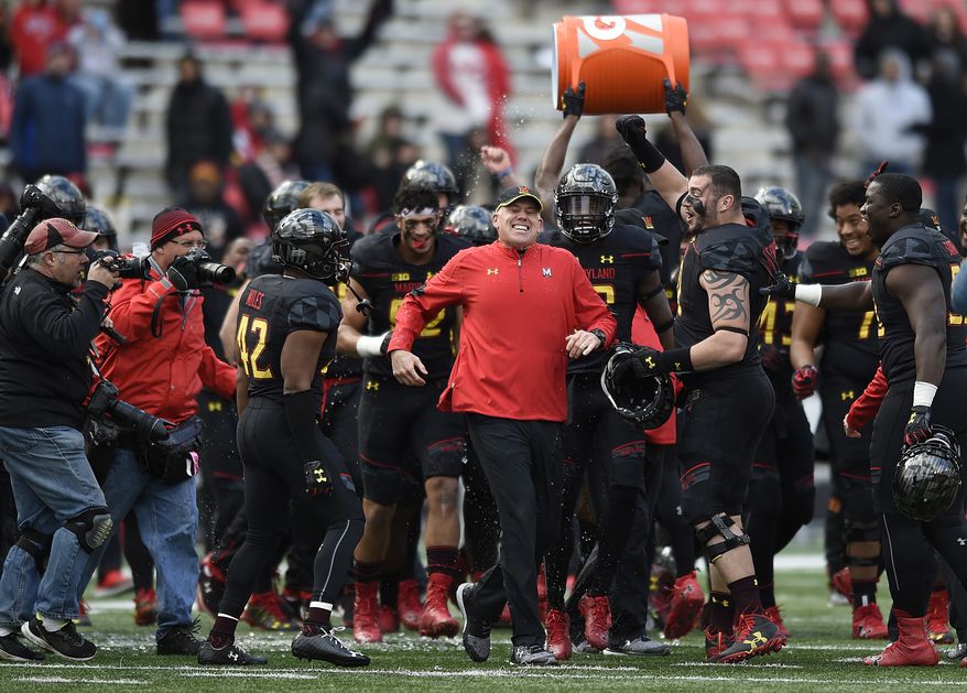 Maryland head coach DJ Durkin, center, runs away from his team after getting doused as they celebrate defeating Rutgers 31-13 in an NCAA college football game, Saturday, Nov. 26, 2016 in College Park, Md. (AP Photo/Gail Burton) **FILE**