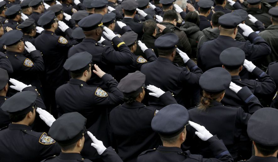 NYPD officers salute during the funeral of Officer Wenjian Liu in the Brooklyn borough of New York on Jan. 4, 2015. Liu and his partner, officer Rafael Ramos, were killed Dec. 20, 2014, as they sat in their patrol car on a Brooklyn street. The shooter, Ismaaiyl Brinsley, later killed himself. (Associated Press)