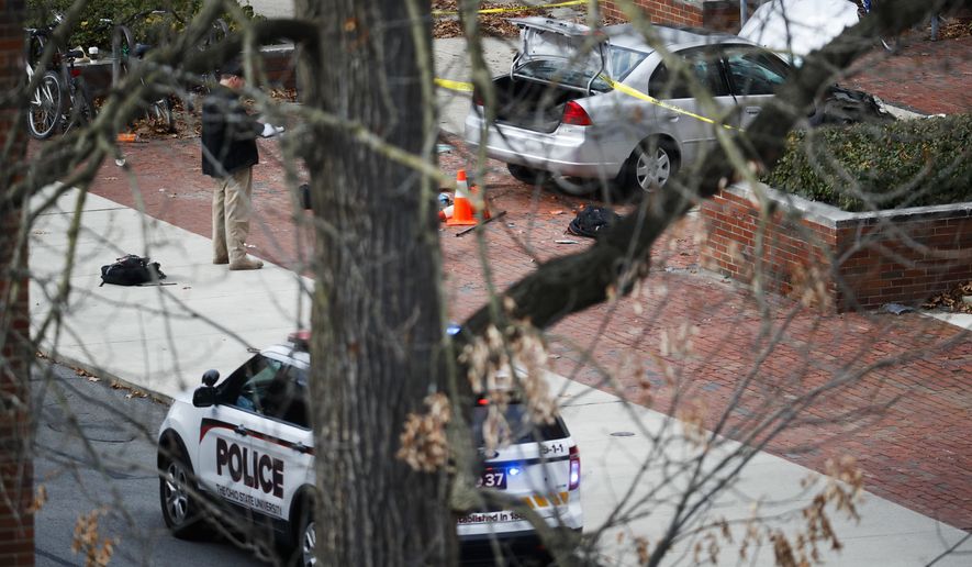 A car inside a police line sits on the sidewalk as authorities respond to an attack on campus at Ohio State University, Monday, Nov. 28, 2016, in Columbus, Ohio. Several were injured after a man plowed his car into a group of pedestrians at the university and began stabbing people with a butcher knife Monday before he was shot to death by a police officer. (AP Photo/John Minchillo)