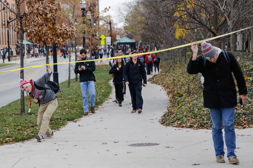 Ohio State students duck under police tape after a shelter-in-place notification was lifted following an attack Monday, Nov. 28, 2016, at Ohio State University in Columbus, Ohio. (Joshua A. Bickel/The Columbus Dispatch via AP)