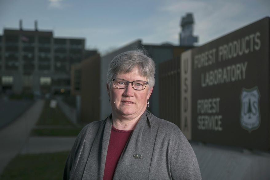 In a Tuesday, Nov. 21, 2016 photo, Melissa Baumann, a chemist at Forest Products Lab, stands in outside of the facility in Madison, Wis. Baumann is one of the nation's 4 million or so federal workers who is watching anxiously as President-elect Donald Trump looks to set his agenda on federal employees in motion. (AP Photo/Andy Manis)