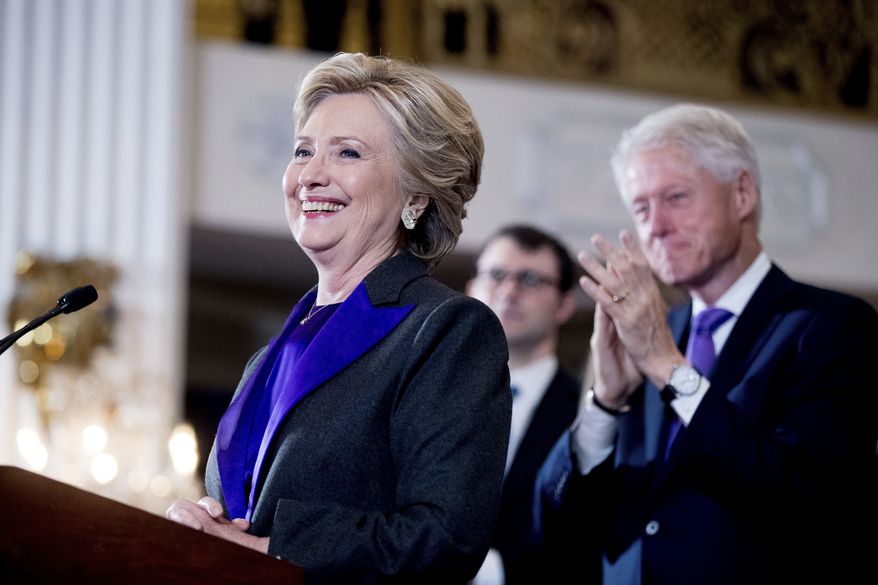 Hillary Clinton, accompanied by former President Bill Clinton, right, pauses while speaking to staff and supporters at the New Yorker Hotel in New York, Nov. 9, 2016. Hillary Clinton introduced singer and UNICEF Goodwill Ambassador Katy Perry on Tuesday, Nov. 29, at the annual event in New York. (AP Photo/Andrew Harnik) ** FILE **
