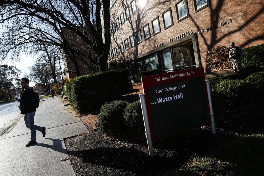 Students pass Watts Hall as they return to class following an attack at The Ohio State University campus the previous day, Tuesday, Nov. 29, 2016, in Columbus, Ohio. Investigators are looking into whether a car-and-knife attack at Ohio State University that injured several people was an act of terror. (AP Photo/John Minchillo)