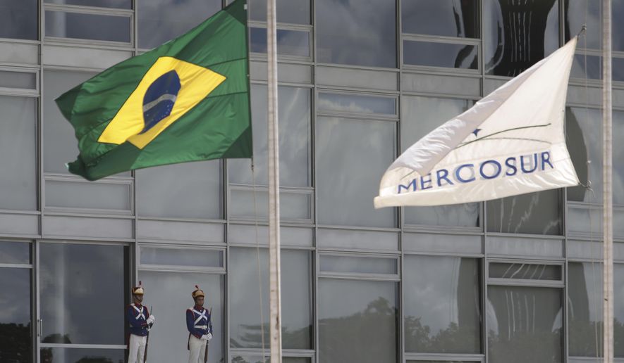 The Brazilian national flag along with a MERCOSUR banner fly at half-staff to honor plane crash victims, outside the Planalto Presidential Palace in Brasilia, Brazil, Tuesday, Nov. 29, 2016.  A chartered plane carrying a Brazilian soccer team to the biggest match of its history crashed into a Colombian hillside and broke into pieces, killing 75 people and leaving six survivors, Colombian officials said Tuesday. The Brazilian government declared three days of mourning. (AP Photo/Eraldo Peres)