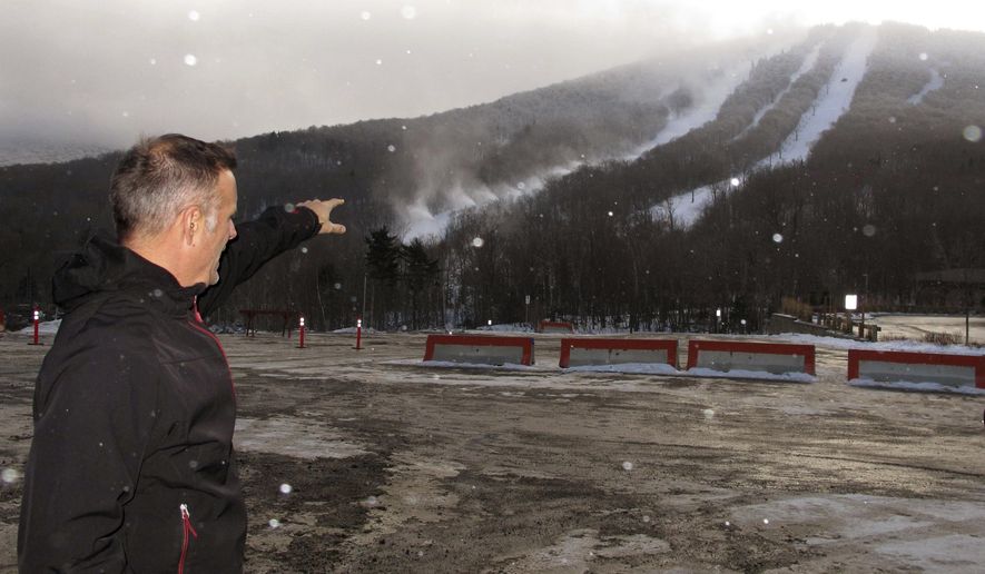 In this Tuesday, Nov. 28 2016 photo. Steve Wright, general manager at Jay Peak Resort, points out at new snowmaking guns blowing snow onto a lower trail of the resort in Jay, Vt. Seven months after the Securities and Exchange Commission accused Jay Peak's owner of misappropriating millions of dollars in foreign investors' money, the resort is expected to officially open for the ski season on Saturday. (AP Photo/Lisa Rathke)