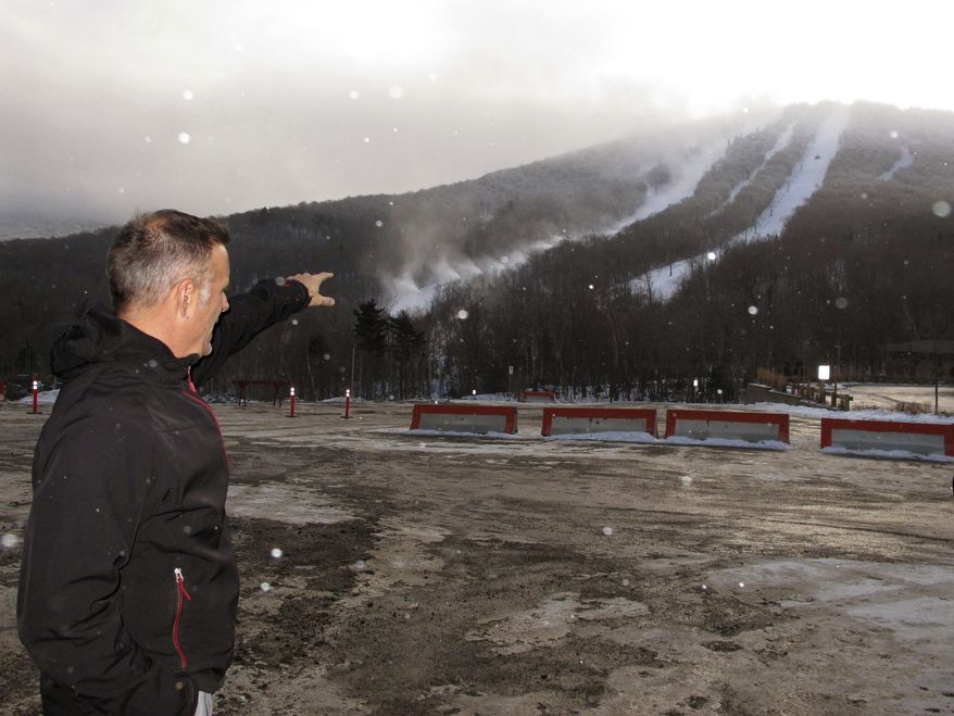 In this Tuesday, Nov. 28 2016 photo. Steve Wright, general manager at Jay Peak Resort, points out at new snowmaking guns blowing snow onto a lower trail of the resort in Jay, Vt. Seven months after the Securities and Exchange Commission accused Jay Peak's owner of misappropriating millions of dollars in foreign investors' money, the resort is expected to officially open for the ski season on Saturday. (AP Photo/Lisa Rathke)