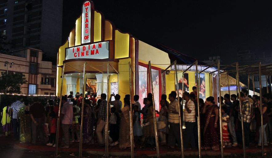 People stand in a queue to enter a movie theater in Kolkata, India, on Oct. 11, 2013. (Associated Press) **FILE**