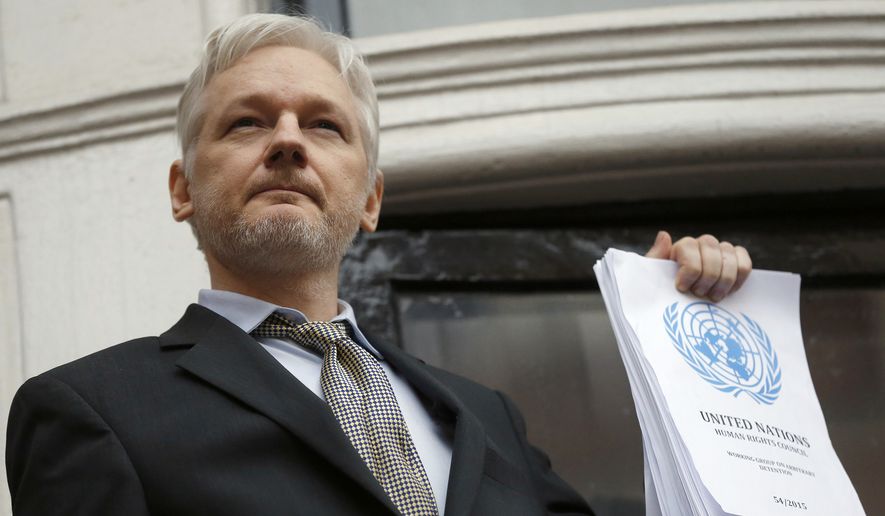 WikiLeaks founder Julian Assange holds a U.N. report as he speaks on the balcony of the Ecuadorian Embassy in London in this Friday, Feb. 5, 2016, file photo. (AP Photo/Frank Augstein, File)