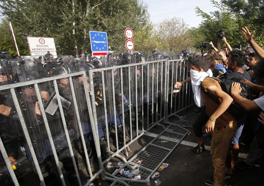 In this Sept. 16, 2016 picture migrants protest at the "Horgos 2" border crossing into Hungary, near Horgos, Serbia. A Hungarian court on Wednesday Nov. 30, 2016 has sentenced a Syrian man to 10 years in prison for taking part in a Sept. 2015 riot after Hungary closed its borders to migrants and refugees. Dozens of police officers, migrants and some journalists were injured in clashes on Sept. 16, 2015, a day after Hungary closed off its border with Serbia with a fence protected by razor wire, stranding hundreds of migrants. (AP Photo/Darko Vojinovic/File)