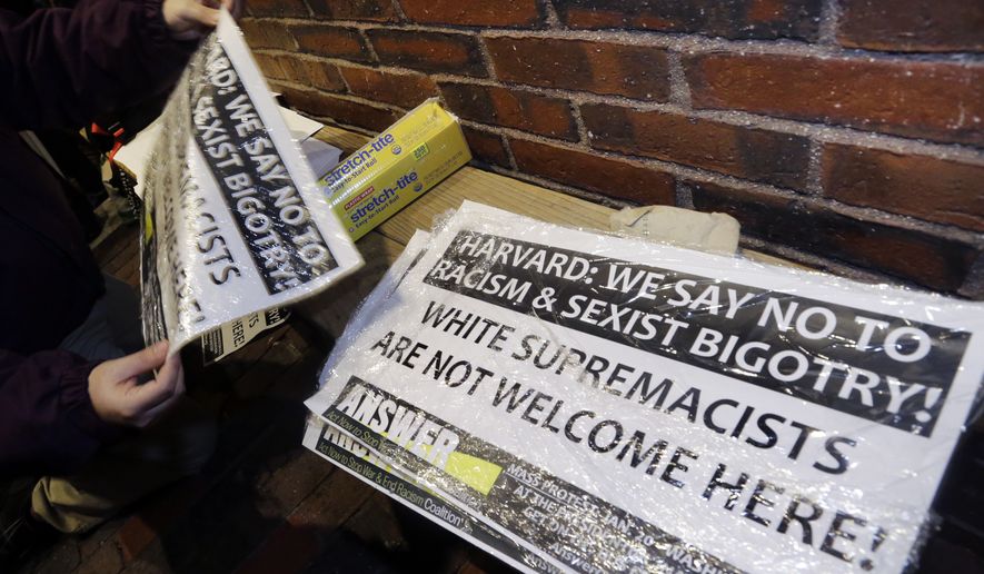 A protester picks up a sign outside Harvard's John F. Kennedy School of Government, Wednesday, Nov. 30, 2016, in Cambridge, Mass. where the Institute of Politics is hosting a forum featuring political strategists from the 2016 presidential election campaigns. President-elect Donald Trump advisor, Stephen K. Bannon, was on the list of those scheduled to attend, but reportedly changed his plans. (AP Photo/Elise Amendola)