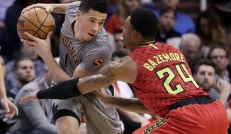Phoenix Suns guard Devin Booker is defended by Atlanta Hawks forward Kent Bazemore (24) during the first half of an NBA basketball game, Wednesday, Nov. 30, 2016, in Phoenix. (AP Photo/Matt York)
