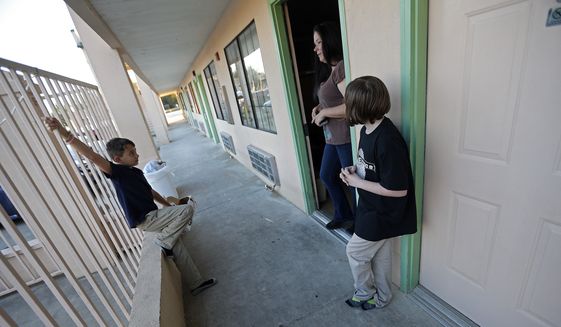 Ashleigh Dickerson and her daughter Christian, 10, talk with temporary neighbor Daron Brose, in the hotel where they are now living, in Denham Springs, La., Wednesday, Nov. 16, 2016. Before the floods came, Ashleigh Dickersons family lived in a three-bedroom house on a private road with plenty of room for her young children to play. (AP Photo/Gerald Herbert)