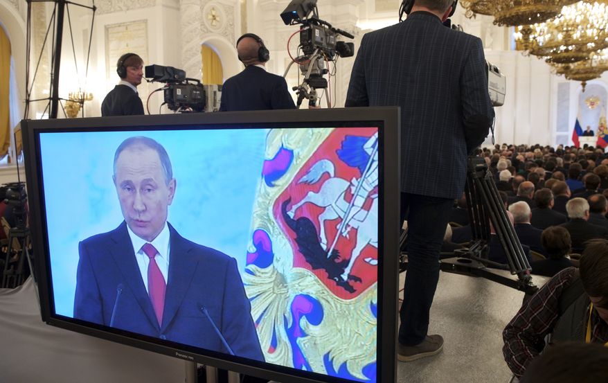 Russian President Vladimir Putin is shown on a screen as he gives his annual state of the nation address in the Kremlin in Moscow, Russia, Thursday, Dec. 1, 2016. (AP Photo/Pavel Golovkin)