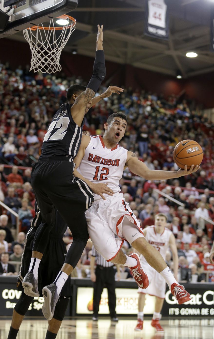 FILE - In this March 5, 2015, file photo, Davidson's Jack Gibbs (12) looks to score against Virginia Commonwealth's Terry Larrier (22) during the second half of an NCAA college basketball game in Davidson, N.C. He may not be Stephen Curry, but another top notch shooter has emerged at Davidson in Jack Gibbs. (AP Photo/Bob Leverone, File)