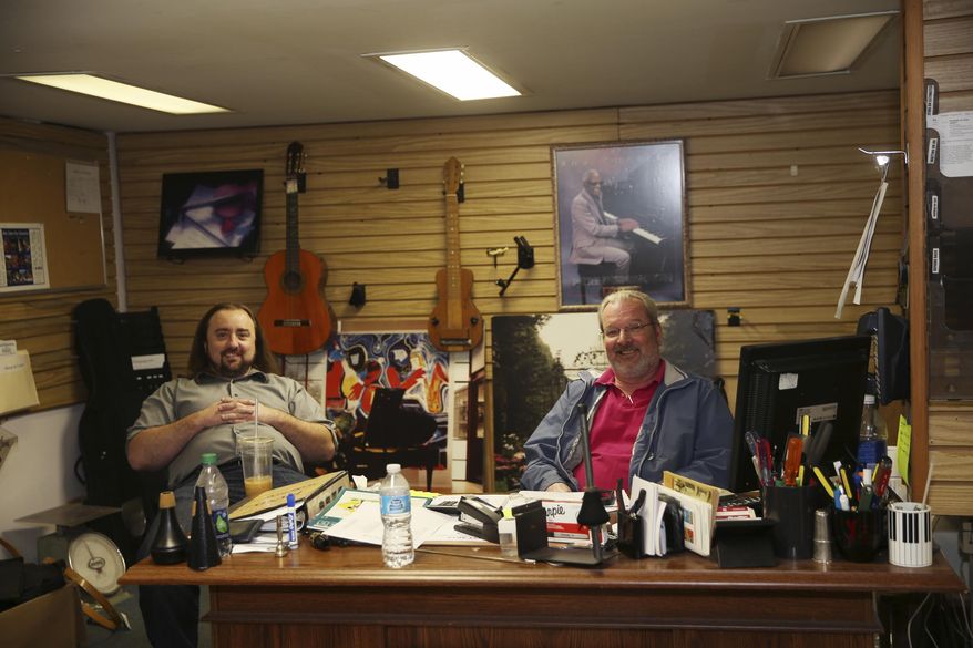 In a Nov. 22, 2016 photo, Steve Gross, left, piano manager for 10 years with Yamaha, is helping Jerry Ridenhour, son of Jim and grandson of Elmer Ridenhour, who started Ridenhour Music 74 years ago, sell the inventory and close the store. After more than 70 years, Ridenhour Music will cease operation in December. (Stephanie Klein-Davis/The Roanoke Times via AP)