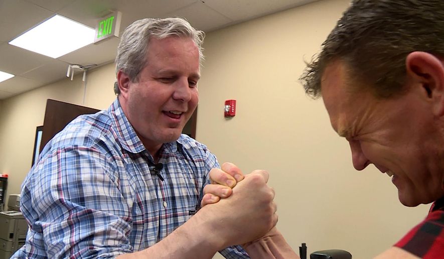 In this image taken from video on Nov. 15, 2016, Robert Baxter arm-wrestles Spencer Lightningfire in his South Jordan, Utah, office. Baxter is up to his neck in competition in both the restaurant business and the world of arm wrestling, but says facing off against an enemy has brought him some of the best friends he'll ever have. (Ray Boone/KSL-TV/The Deseret News via AP)