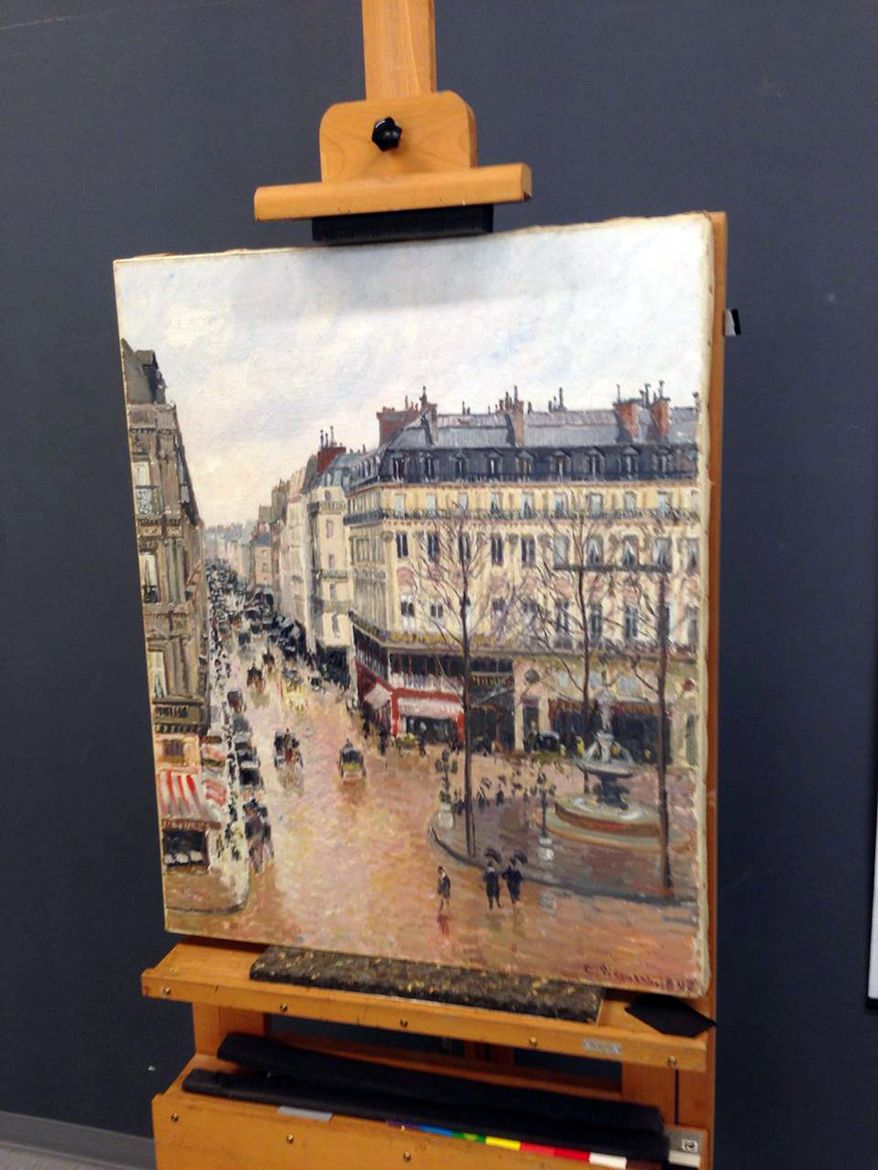This Sept. 22, 2014 photo made available by Professor Jonathan Petropolous shows Camille Pissarro's 1897 Impressionist masterpiece, "Rue Saint-Honoré, dans l'après-midi. Effet de pluie," during an examination at the Museo Thyssen-Bornemisza in Madrid. In the 16-year battle over this priceless painting looted by the Nazis, there is one point on which all sides agree: When Lilly Cassirer and her husband fled Germany ahead of the Holocaust in 1939, the Jewish couple had to surrender their masterpiece in exchange for their lives. What they disagree on is who owns the painting now. Are the owners the descendants of Cassirer or the Spanish museum that acquired the painting decades ago in good faith. On Monday, Dec. 5, 2016, the case will be argued in a federal appeals court. (Jonathan Petropolous via AP)