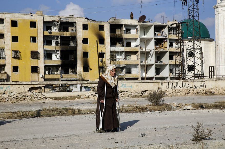 In this Sunday, Dec. 4, 2016, photo, Nisrin Malaji returns to her looted home in the Hanano district of eastern Aleppo, Syria. It's a painful homecoming shared by hundreds of Syrians who are returning to areas devastated by years of war and then retaken from the city's embattled rebels in a recent government offensive. (AP Photo/Hassan Ammar)