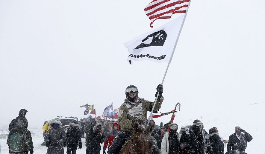 U.S. Navy veteran Kash Jackson rides a horse during a march with fellow veterans and Native Americans to a closed bridge outside the Oceti Sakowin camp where people have gathered to protest the Dakota Access oil pipeline in Cannon Ball, N.D., Monday, Dec. 5, 2016. (AP Photo/David Goldman)