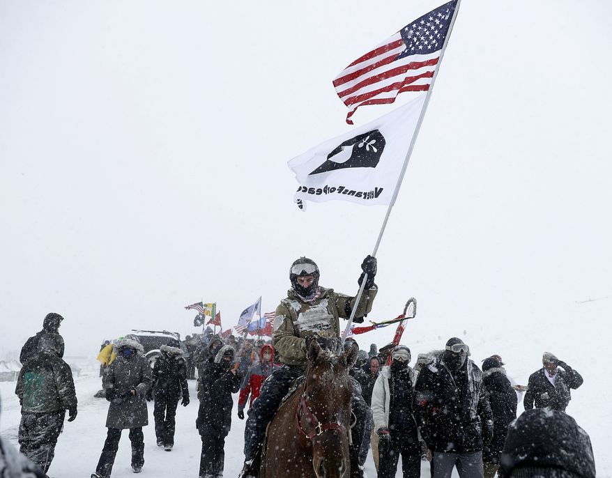 U.S. Navy veteran Kash Jackson rides a horse during a march with fellow veterans and Native Americans to a closed bridge outside the Oceti Sakowin camp where people have gathered to protest the Dakota Access oil pipeline in Cannon Ball, N.D., Monday, Dec. 5, 2016. (AP Photo/David Goldman)