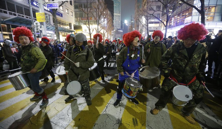 FILE - In this Nov 26, 2016, file photo, protesters beat their drums as they march toward the presidential house during a rally calling for South Korean President Park Geun-hye to step down in Seoul, South Korea. Any good South Korean protest needs a soundtrack, and the music that accompanies the massive rallies on the verge of bringing down President Park includes the mournful, the tongue-and-cheek and a smattering of defiance. Music resounds in the crammed streets around South Korea’s presidential palace. (AP Photo/Ahn Young-joon, File)