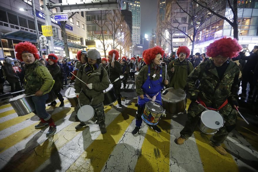 FILE - In this Nov 26, 2016, file photo, protesters beat their drums as they march toward the presidential house during a rally calling for South Korean President Park Geun-hye to step down in Seoul, South Korea. Any good South Korean protest needs a soundtrack, and the music that accompanies the massive rallies on the verge of bringing down President Park includes the mournful, the tongue-and-cheek and a smattering of defiance. Music resounds in the crammed streets around South Korea’s presidential palace. (AP Photo/Ahn Young-joon, File)