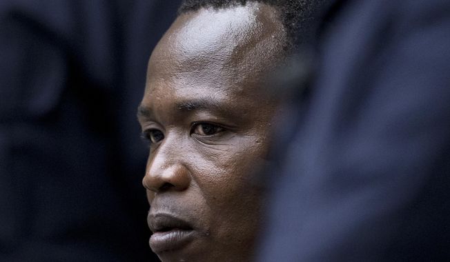Dominic Ongwen, a senior commander in the Lord&#x27;s Resistance Army, whose fugitive leader Kony is one of the world&#x27;s most-wanted war crimes suspects, is flanked by two security guards as he sits in the court room of the International Court in The Hague, Netherlands, Tuesday, Dec. 6, 2016. (AP Photo/Peter Dejong, Pool)