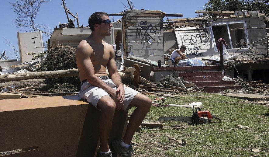 FILE- In this April 29, 2011, file photo, Huston Walters, a sophomore at the University of Alabama from Navarre, Fla., takes a break from cleaning up at his home in the Forest Lake neighborhood after a tornado struck the area. For college administrators, extreme weather is yet another hazard to prepare and practice for on a list that includes infectious disease outbreaks, active shooters and technological outages. (Michelle Lepianka Carter/The Tuscaloosa News via AP, File)