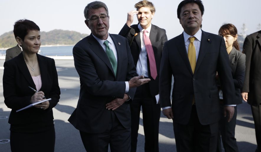 United States Secretary of Defense Ash Carter, second left, speaks to the media as Japanese Deputy Defense Minister Kenji Wakamiya, right, accompanies on the flight deck of the helicopter destroyer Izumo of Japan's Maritime Self-Defense Force (JMSDF) in Yokosuka, south of Tokyo, Tuesday, Dec. 6, 2016. Carter's final swing across Asia as Pentagon chief shines a spotlight on tough issues to be inherited by his successor, from concern in Tokyo and Seoul about being forced to pay more for U.S. military protection to worry across the region about North Korea's nuclear ambitions. (AP Photo/Eugene Hoshiko)